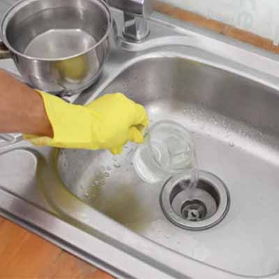 plombier qui débouche une canalisation avec de l'eau chaude